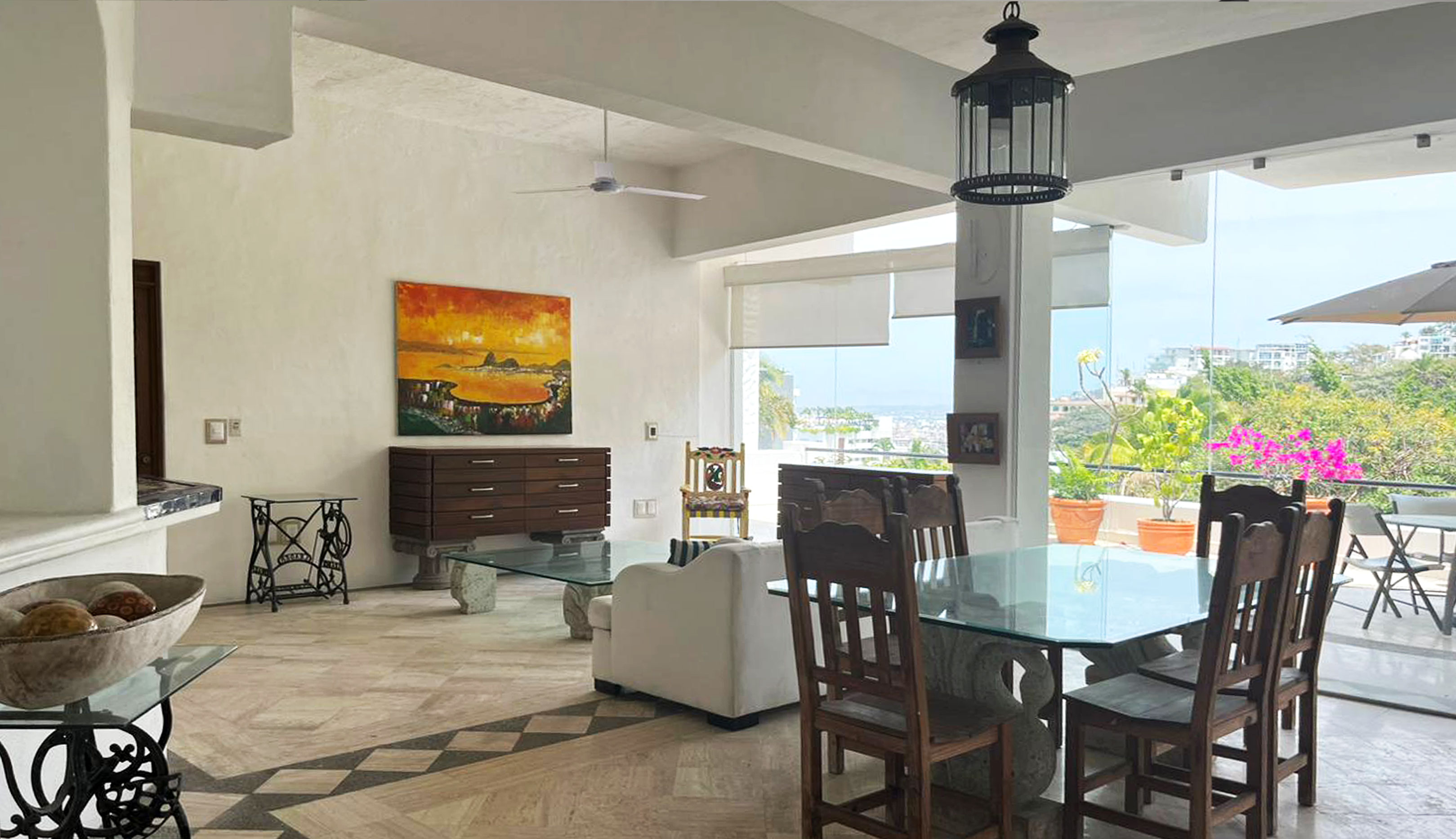 Sala y comedor actuales Almejas 6 — muebles de madera oscura y mesa de vidrio con vista a la terraza