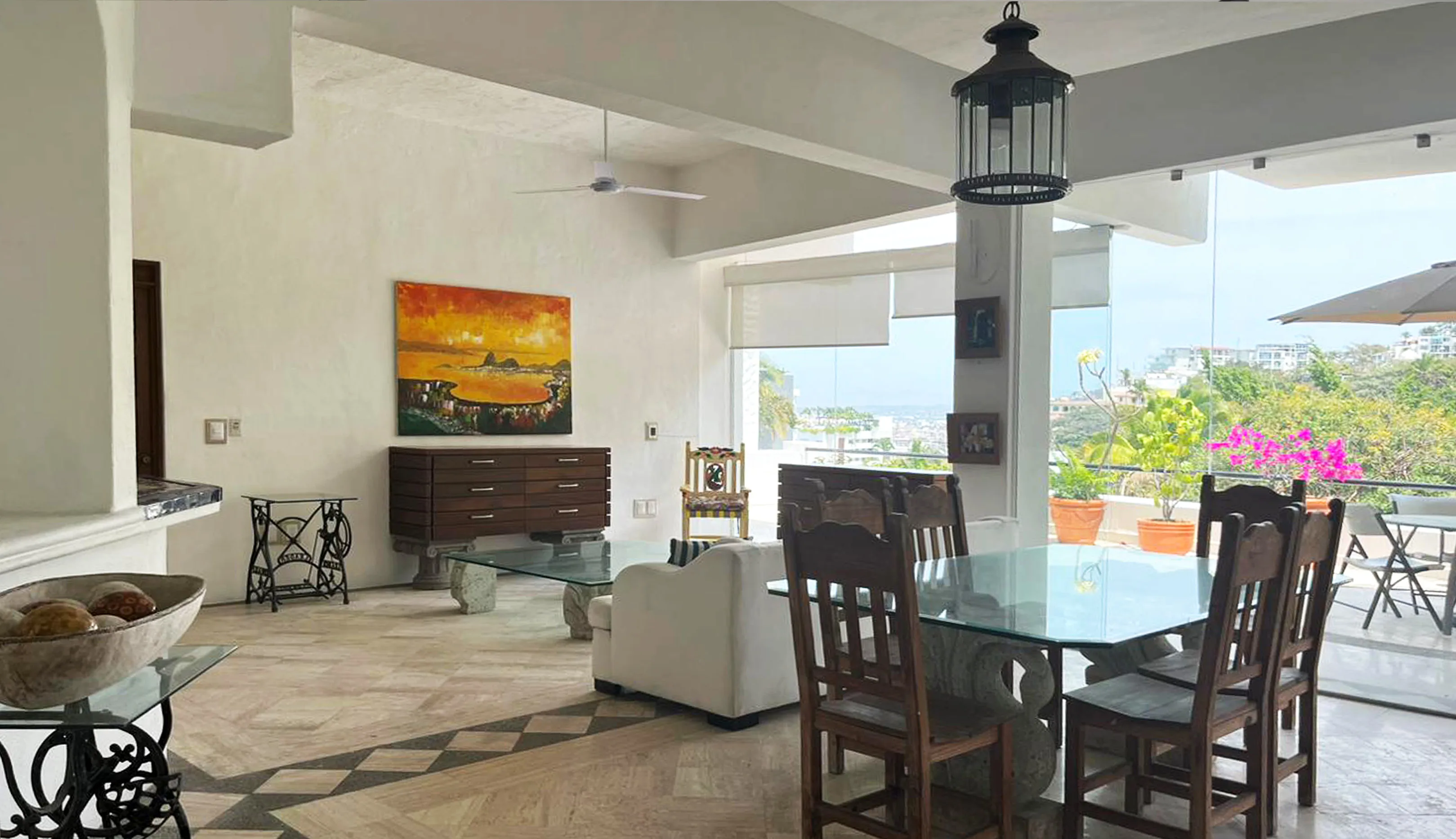 Sala y comedor actuales Almejas 6 — muebles de madera oscura y mesa de vidrio con vista a la terraza