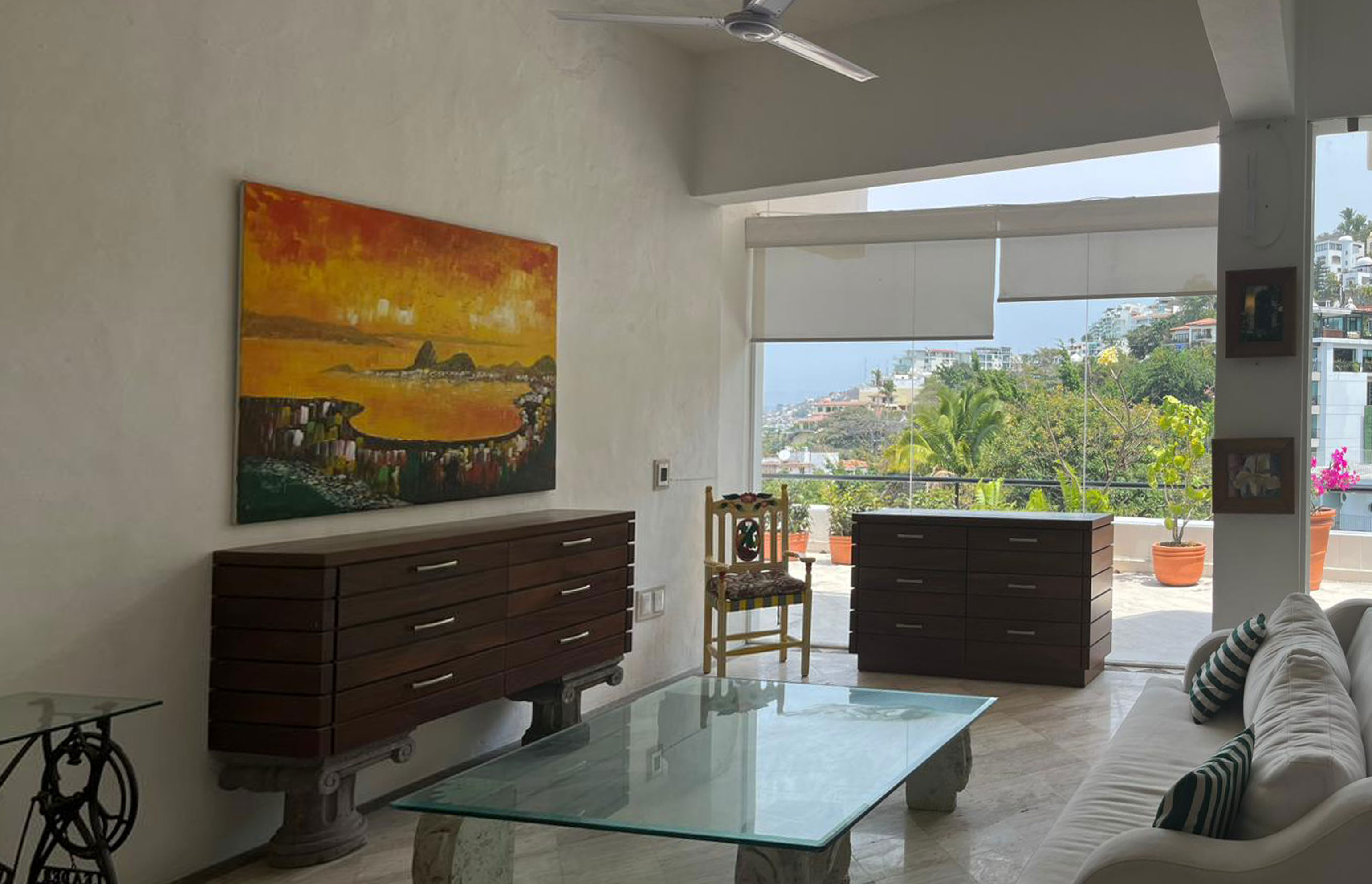Sala actual Almejas 6 — sala con muebles oscuros y ventanería con vista a la bahía de Puerto Vallarta