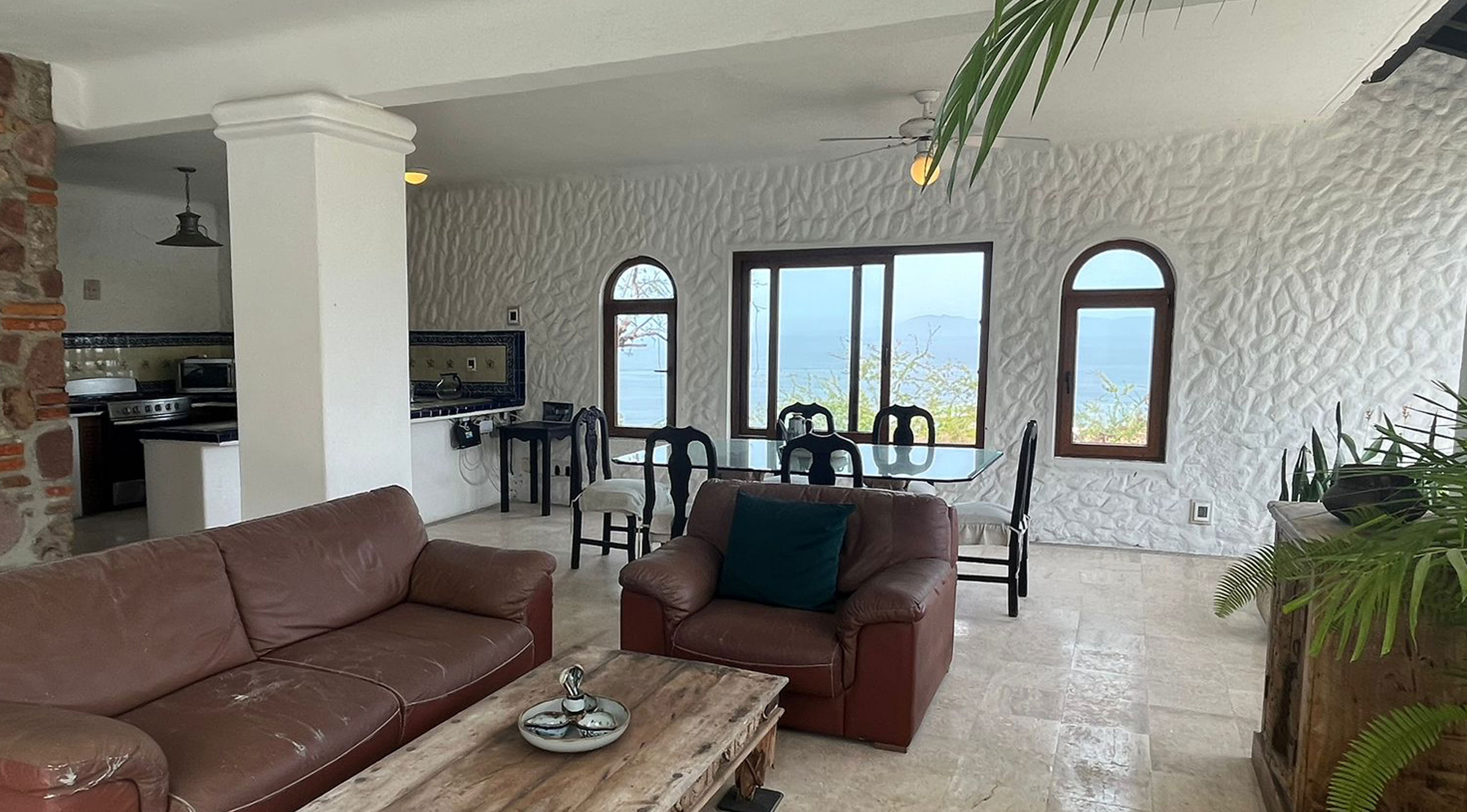 Estado actual Almejas 8 — sala-comedor con muebles oscuros y vista panorámica a la bahía