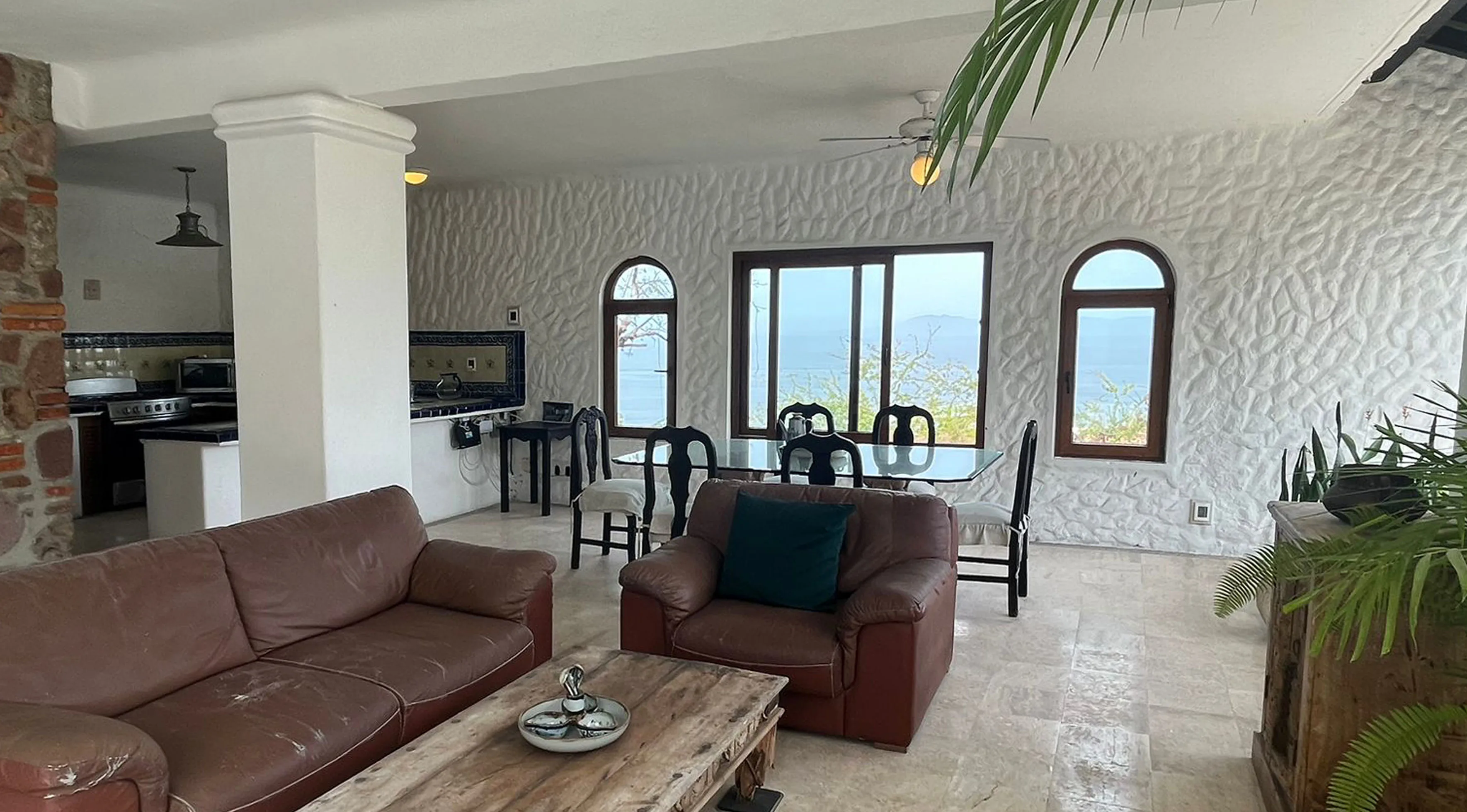 Estado actual Almejas 8 — sala-comedor con muebles oscuros y vista panorámica a la bahía