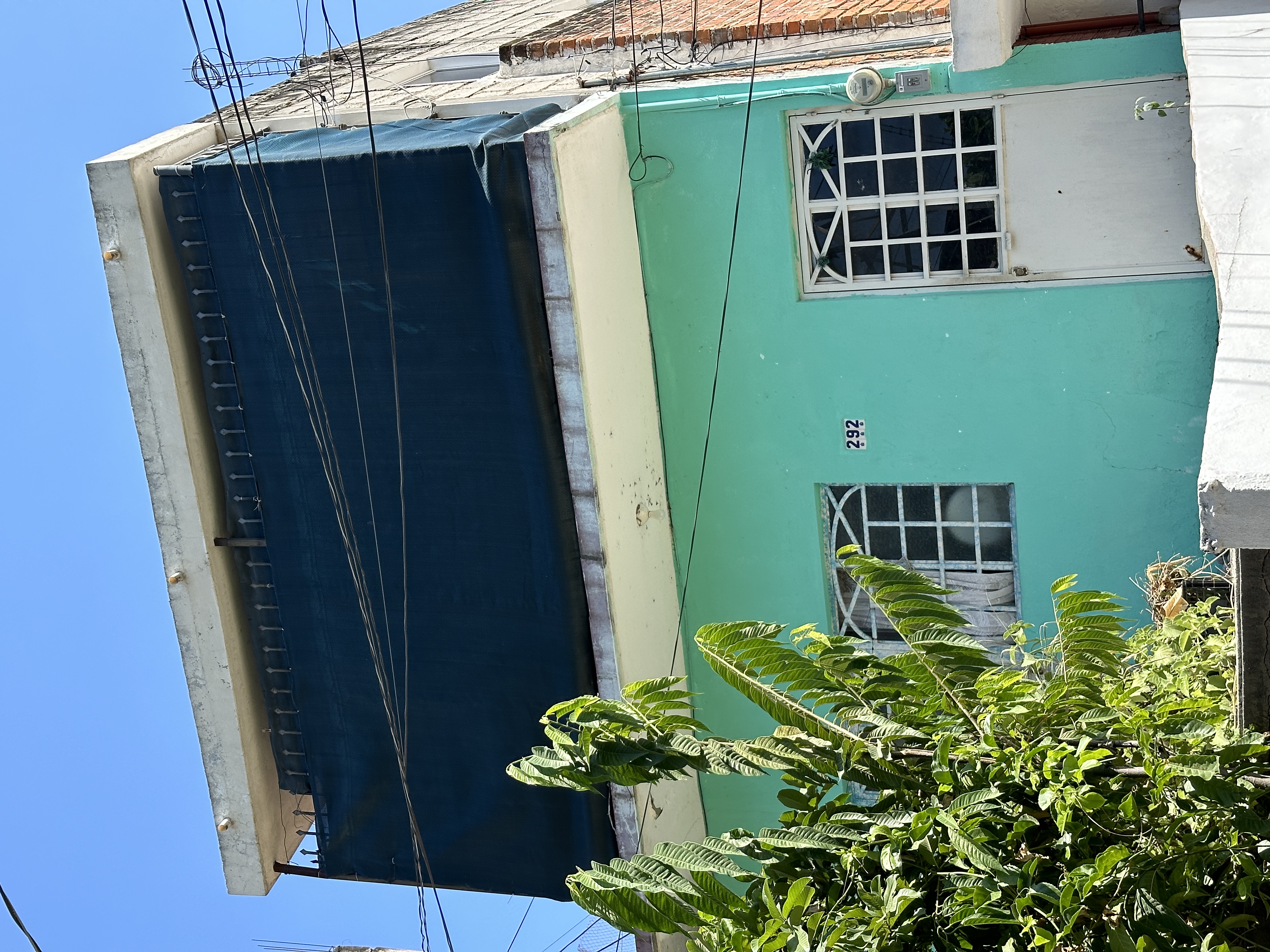 Estado original — fachada de casa unifamiliar color turquesa antes de la intervención