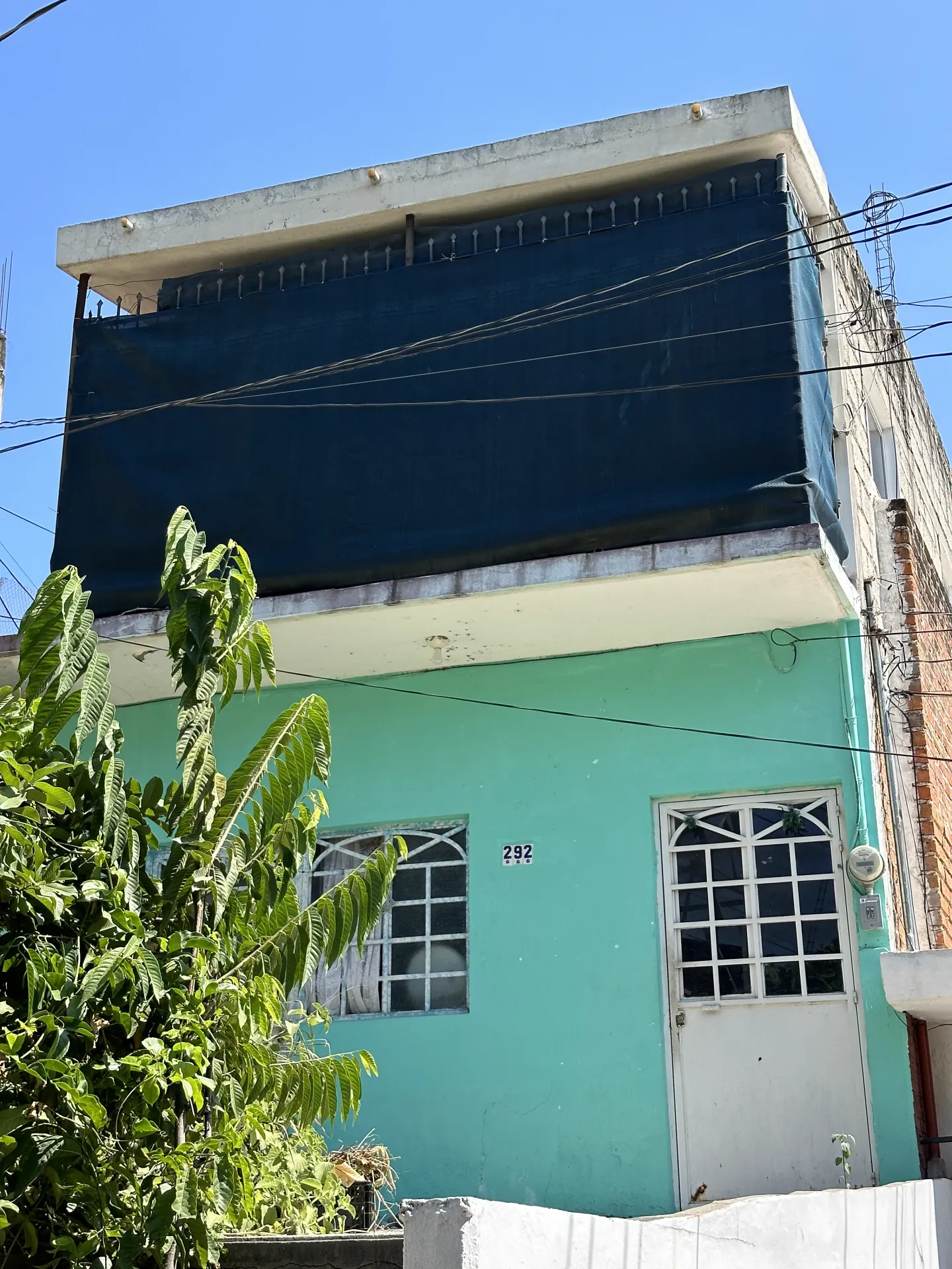 Estado original — fachada de casa unifamiliar color turquesa antes de la intervención
