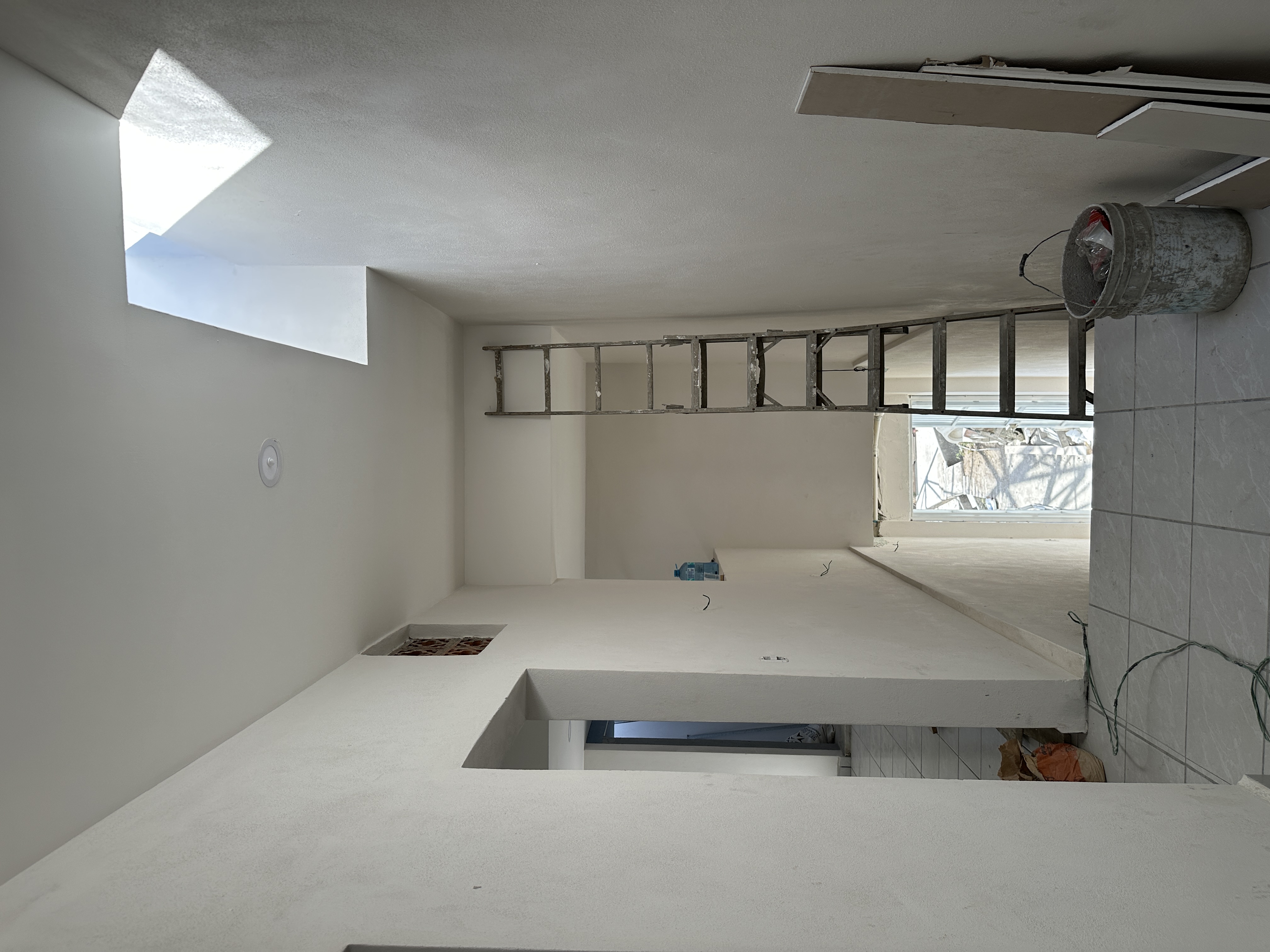 Interior en acabados — espacio diáfano con skylight instalado y mesada de concreto pulido