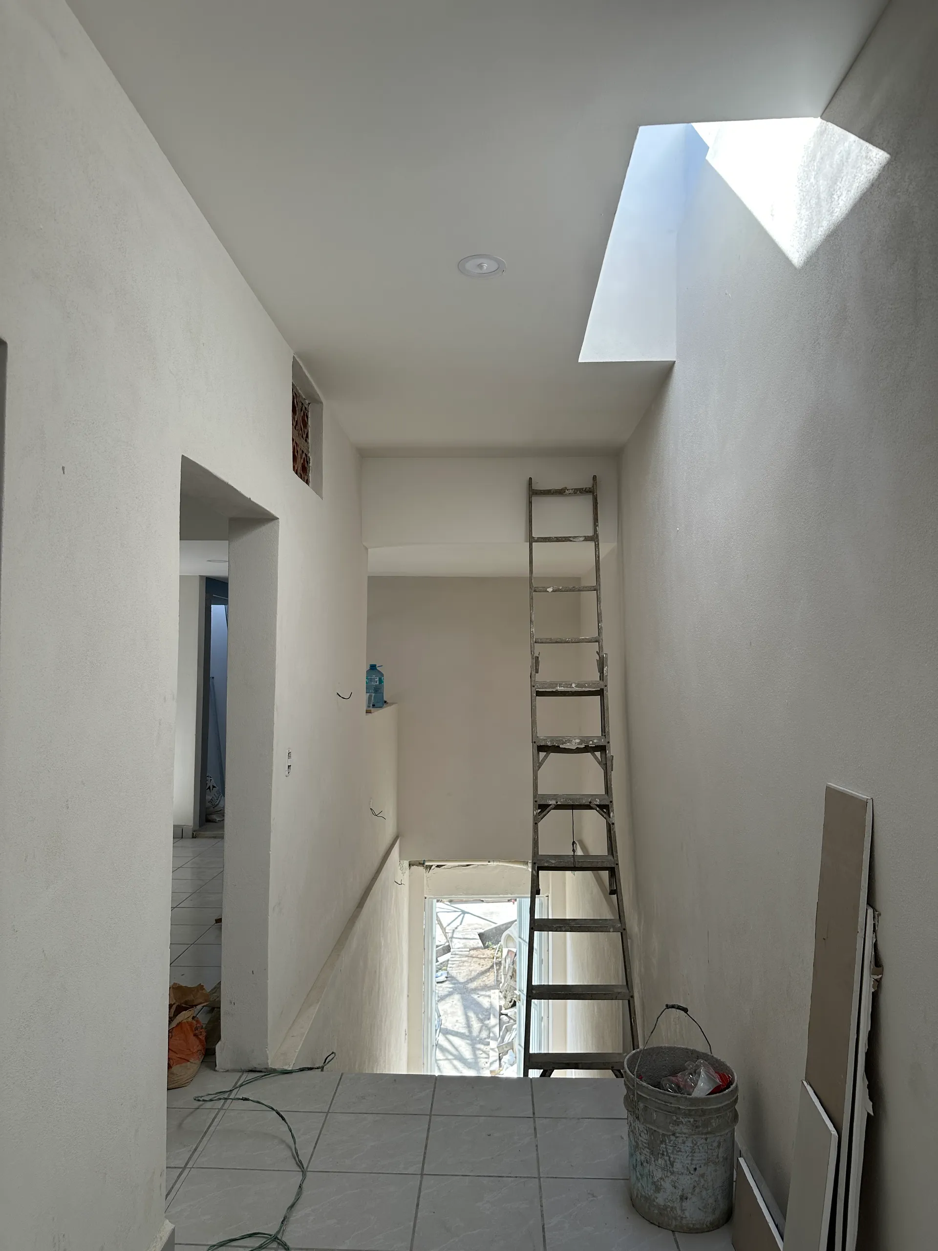 Interior en acabados — espacio diáfano con skylight instalado y mesada de concreto pulido