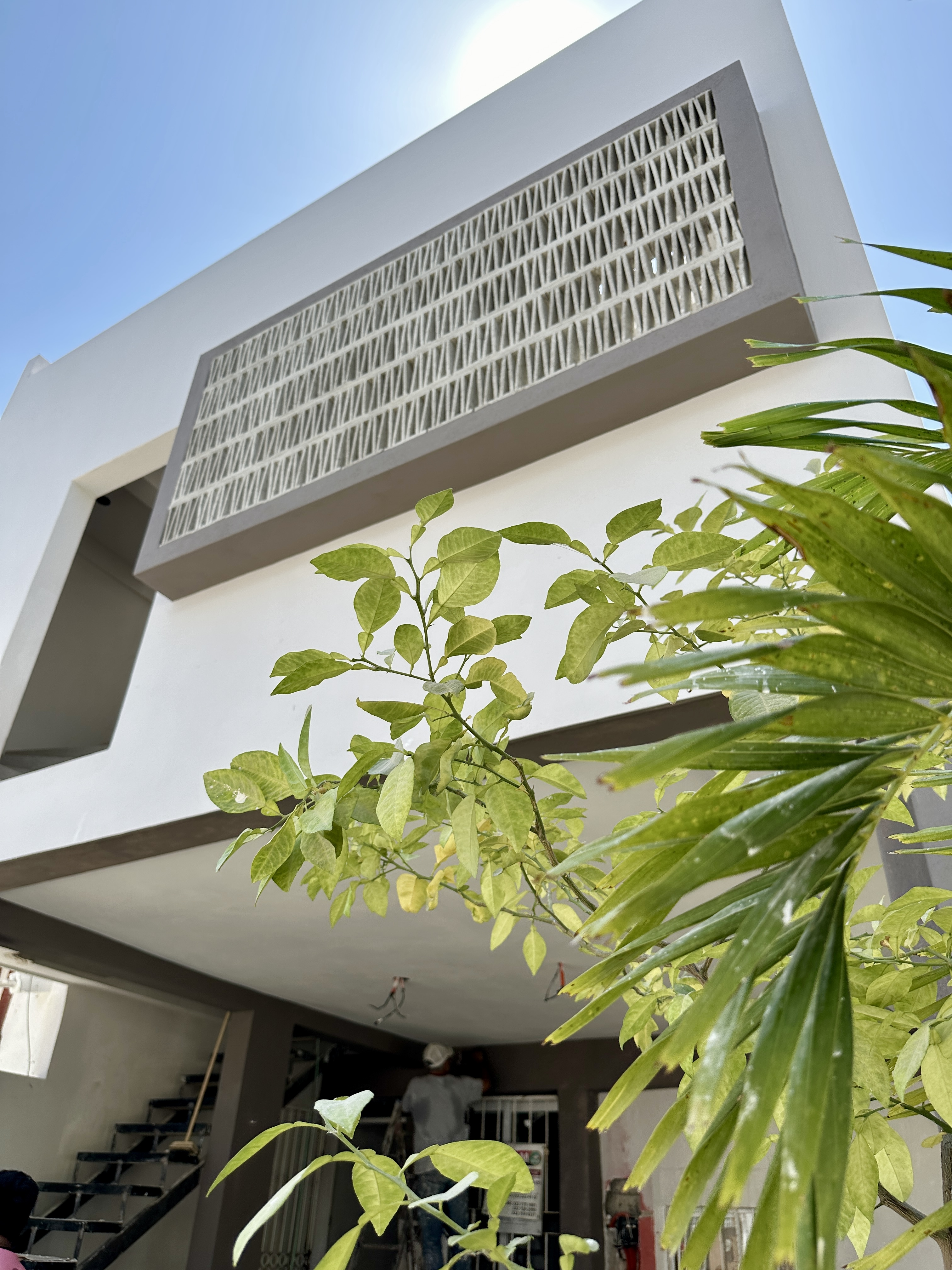 Fachada de Casa Manglar con celosía artesanal de concreto y vegetación tropical