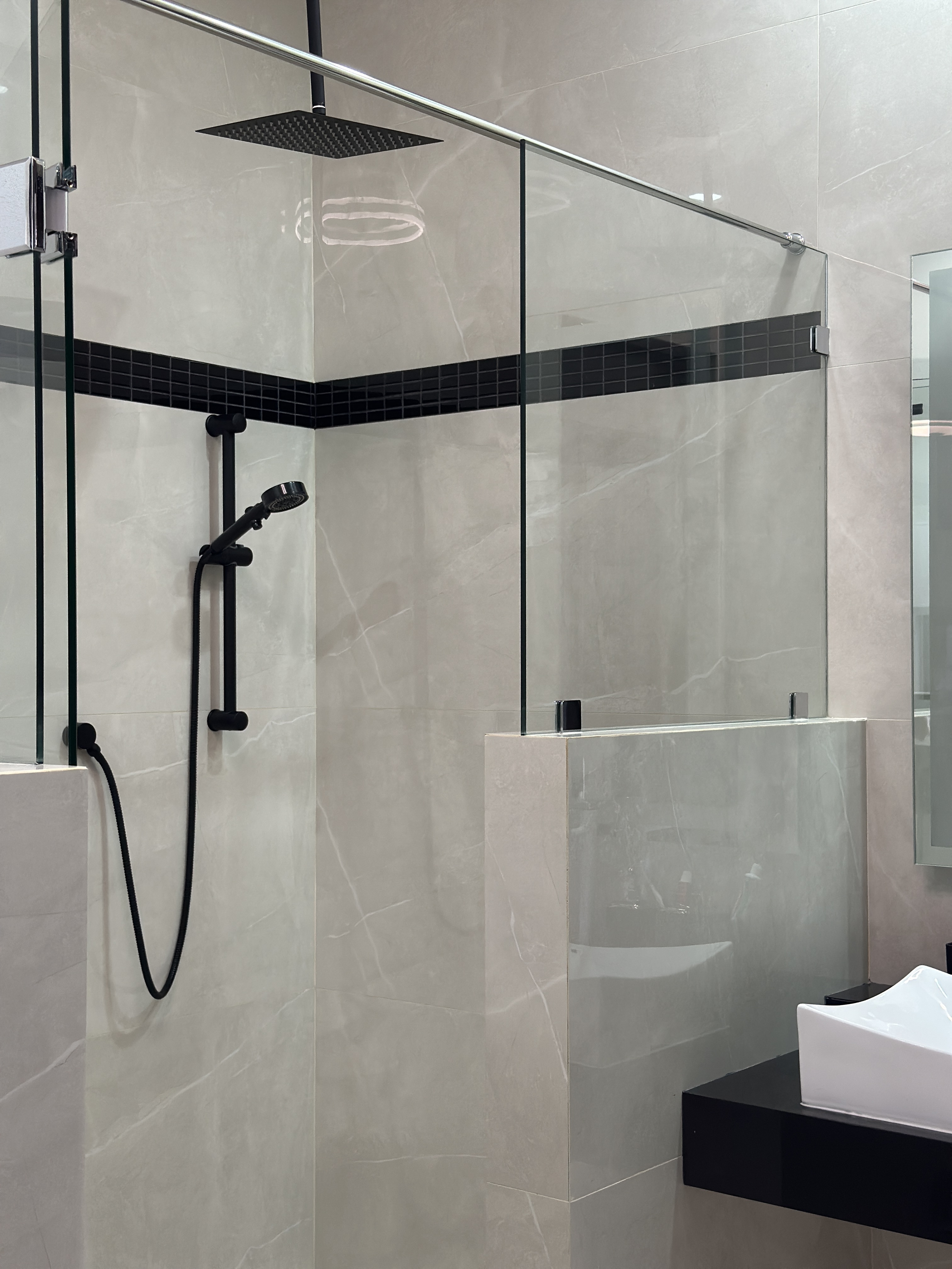Baño con ducha de lluvia negra, vidrio templado y azulejo mármol — Casa Manglar
