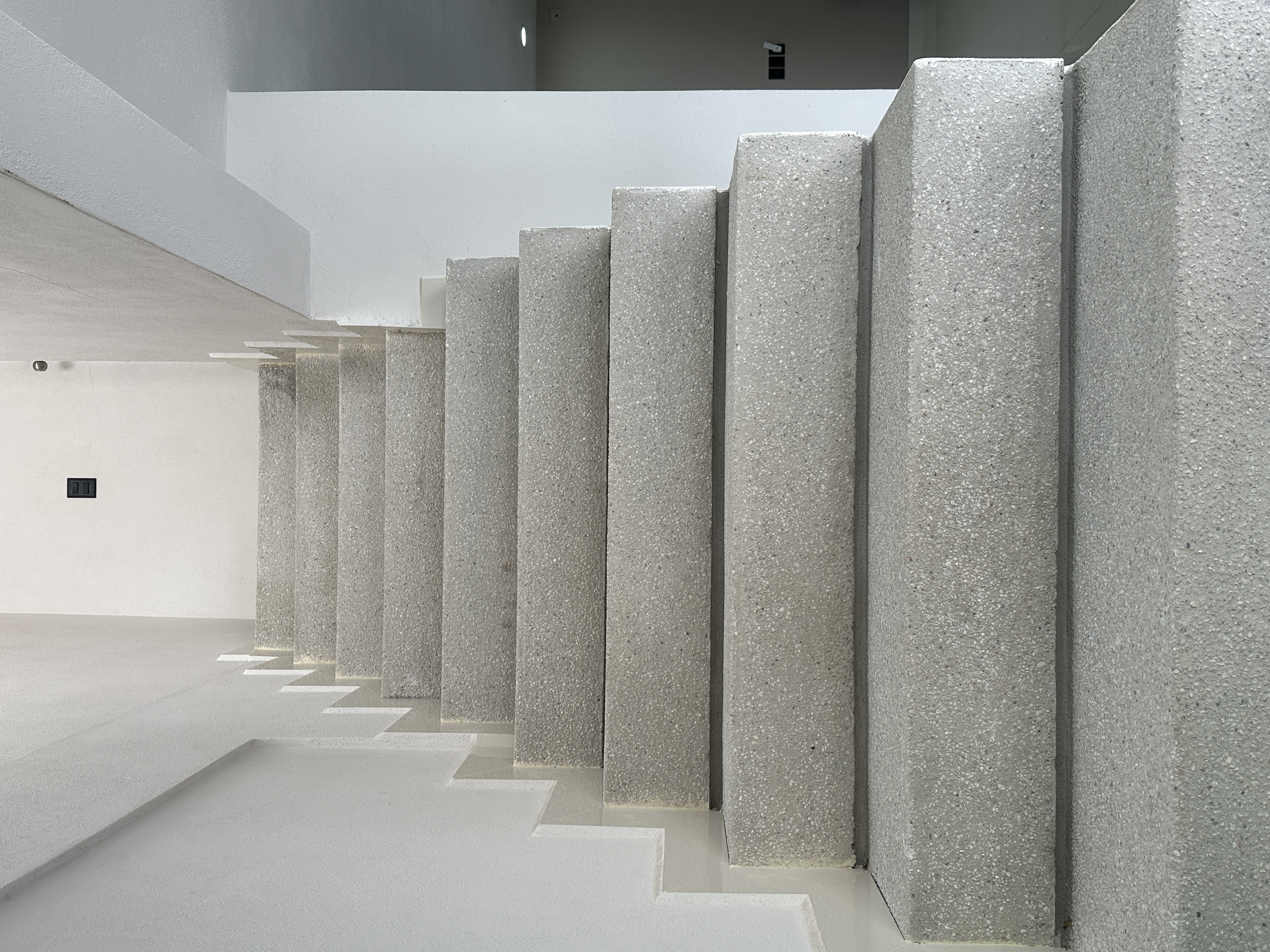 Escalera de terrazzo en perspectiva lateral con iluminación natural — Casa Manglar