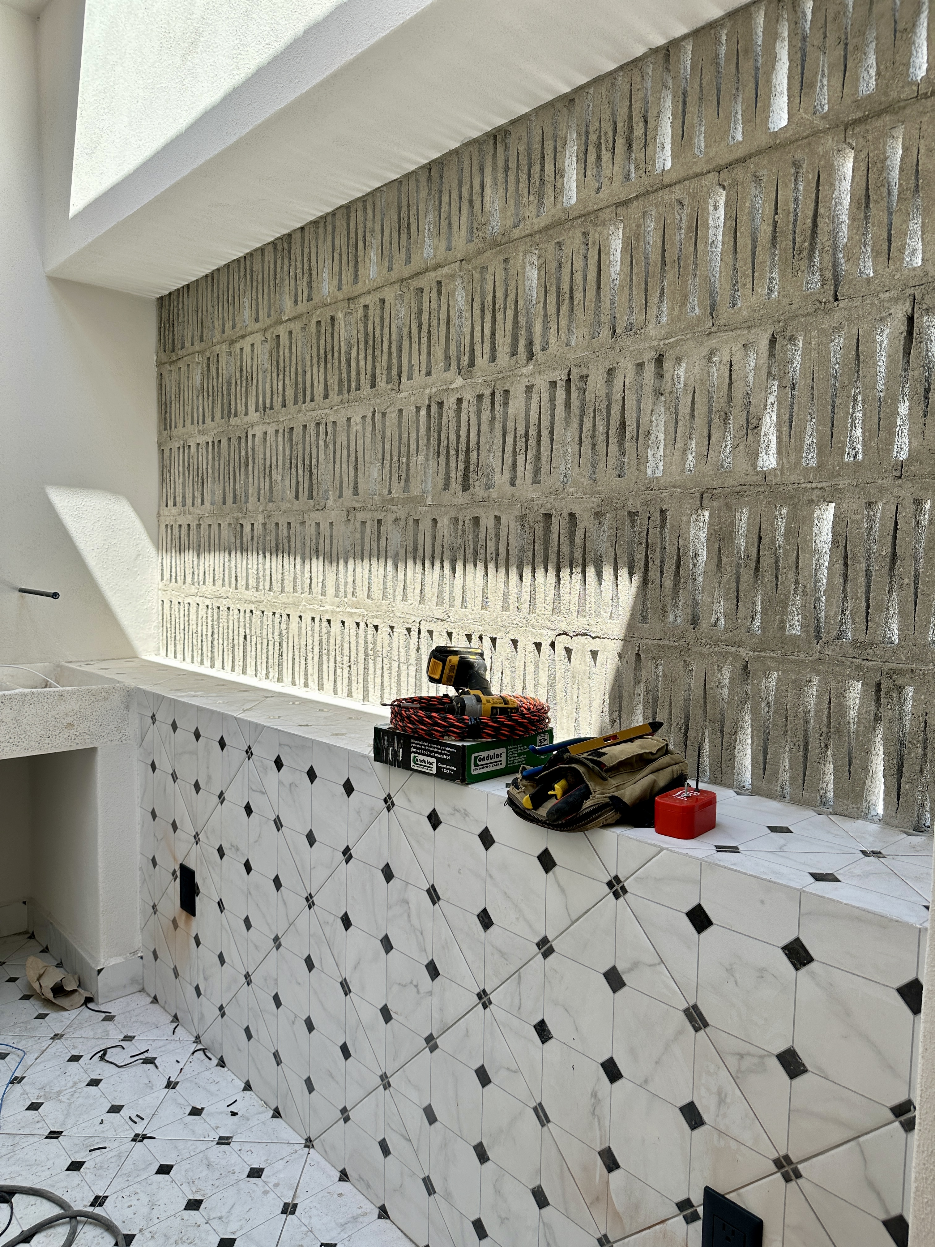 Muro de celosía artesanal de concreto en proceso de instalación — Casa Manglar
