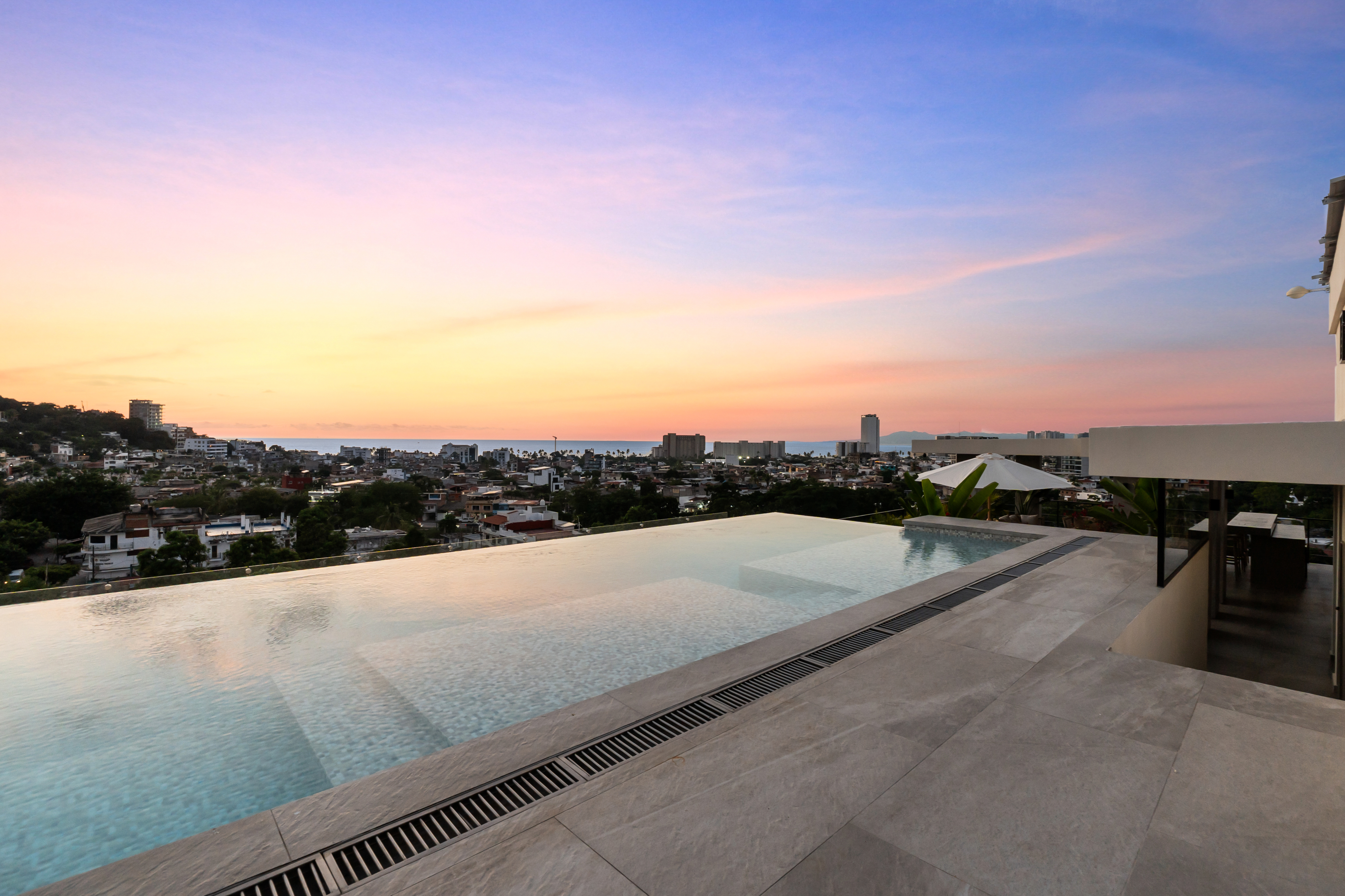 Sky lounge con fire pit y vista a la sierra — rooftop ZUL PV
