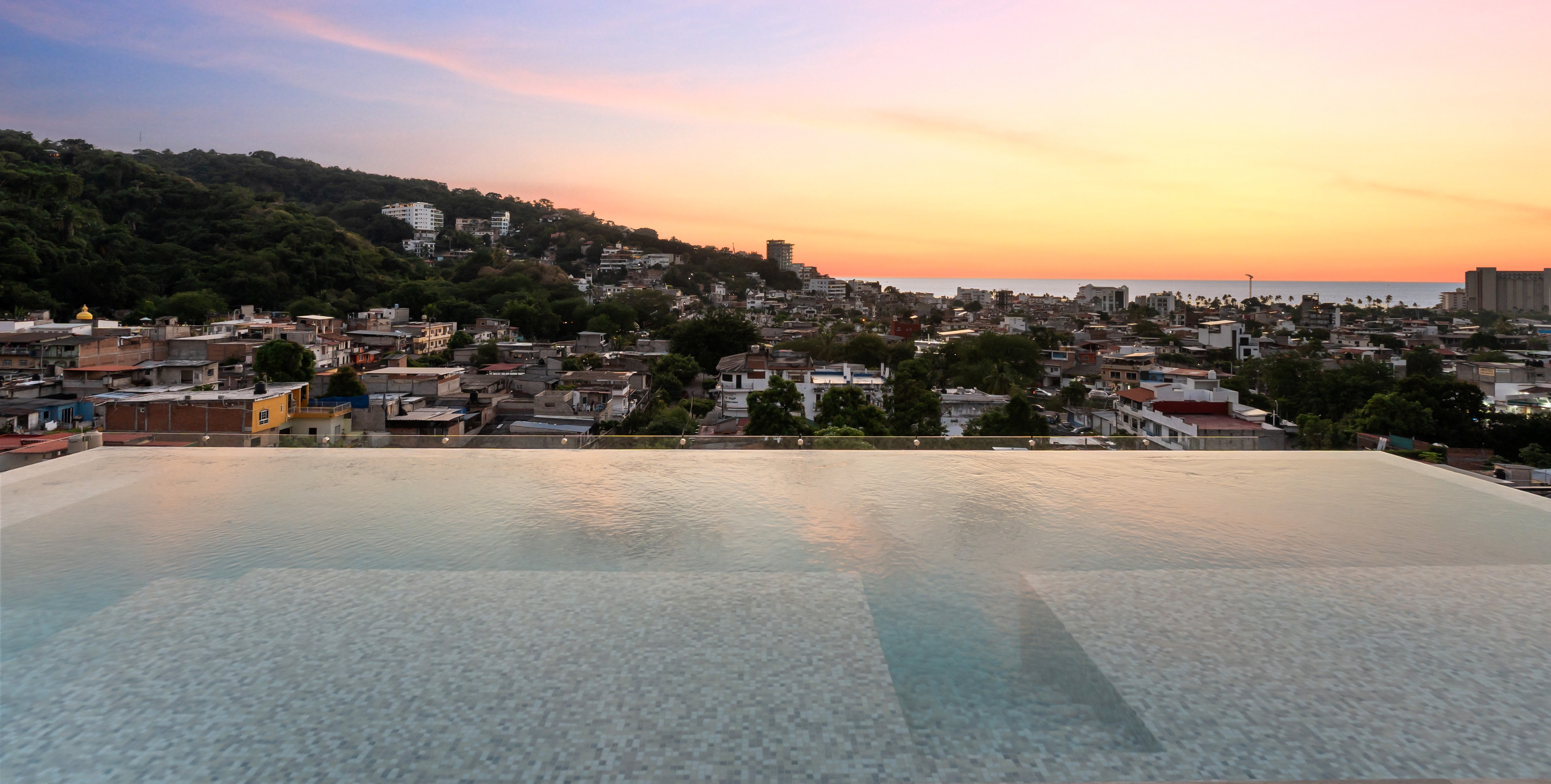 ZUL PV — alberca infinity al atardecer con vista a Puerto Vallarta y el océano Pacífico